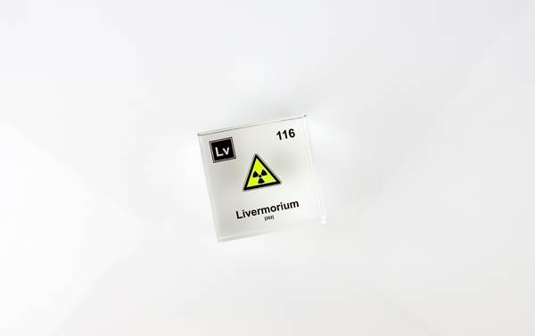 Clear acrylic cube displaying a Livermorium element (Atomic Number 116) embedded within, offering a scientific presentation for collectors and science enthusiasts.