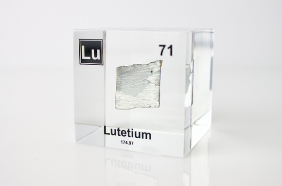 Clear acrylic cube displaying a Lutetium element (Atomic Number 71) embedded within, offering a scientific presentation for collectors and science enthusiasts.