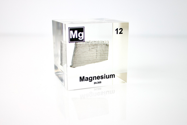 Clear acrylic cube featuring a Magnesium ampule with its atomic number 12. Ideal for educational displays, scientific collections, or as a distinctive decorative item.