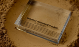 Close-up of a fragment of mammoth hair embedded in clear acrylic. The hair is coarse and dark, with visible texture and fibers, offering a glimpse into the ancient past of this prehistoric animal.