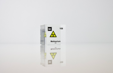 Clear acrylic cube displaying a Meitnerium element (Atomic Number 109) embedded within, offering a scientific presentation for collectors and science enthusiasts.