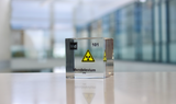 Clear acrylic cube displaying a Mendelevium element (Atomic Number 101) embedded within, offering a scientific presentation for collectors and science enthusiasts.