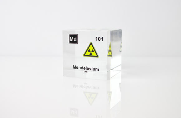 Clear acrylic cube displaying a Mendelevium element (Atomic Number 101) embedded within, offering a scientific presentation for collectors and science enthusiasts.