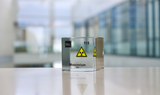 Clear acrylic cube displaying a Moscovium element (Atomic Number 115) embedded within, offering a scientific presentation for collectors and science enthusiasts.