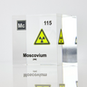 Clear acrylic cube displaying a Moscovium element (Atomic Number 115) embedded within, offering a scientific presentation for collectors and science enthusiasts.