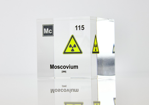 Clear acrylic cube displaying a Moscovium element (Atomic Number 115) embedded within, offering a scientific presentation for collectors and science enthusiasts.