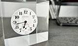 Clear acrylic display case showcasing a detailed watch face with hands and markers, offering a stylish presentation for watch enthusiasts and collectors.