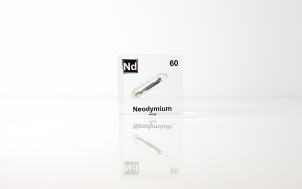 Clear acrylic cube displaying a Neodymium element (Atomic Number 60) embedded within, offering a scientific presentation for collectors and science enthusiasts.