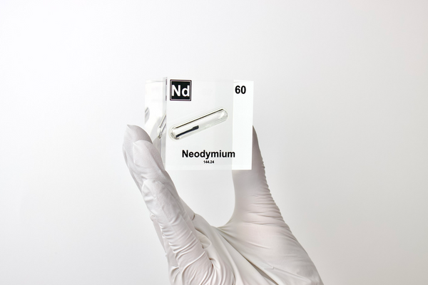 Clear acrylic cube displaying a Neodymium element (Atomic Number 60) embedded within, offering a scientific presentation for collectors and science enthusiasts.