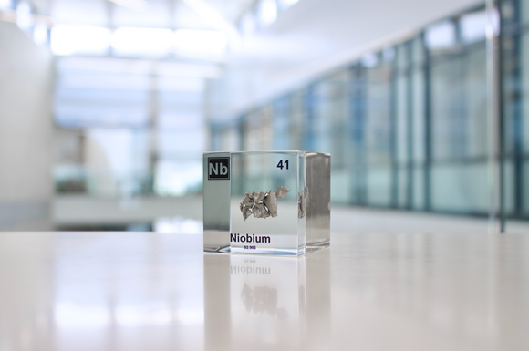 Clear acrylic cube displaying a Niobium element (Atomic Number 41) embedded within, offering a scientific presentation for collectors and science enthusiasts.