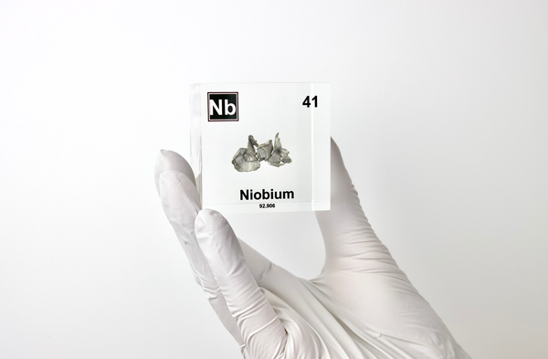 Clear acrylic cube displaying a Niobium element (Atomic Number 41) embedded within, offering a scientific presentation for collectors and science enthusiasts.