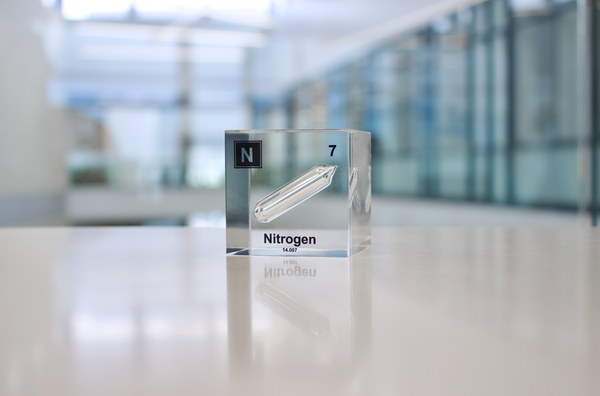 Clear acrylic cube encasing a Nitrogen ampule with its atomic number 7. Ideal for display in educational settings, scientific collections, or as a decorative piece.