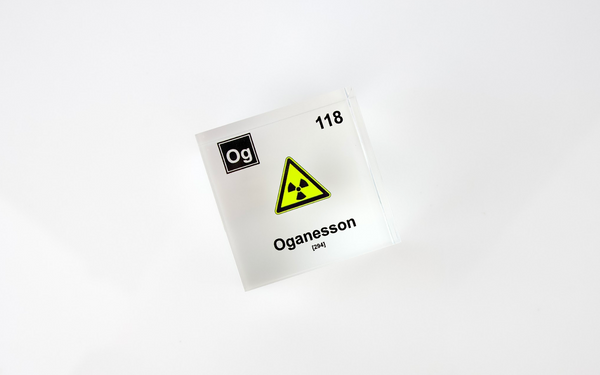 Clear acrylic cube displaying an Oganesson element (Atomic Number 118) embedded within, offering a scientific presentation for collectors and science enthusiasts.