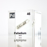 Clear acrylic cube displaying a Palladium element (Atomic Number 46) embedded within, offering a scientific presentation for collectors and science enthusiasts.