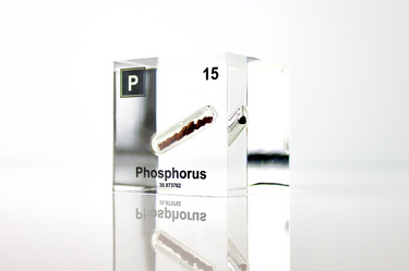 Clear acrylic cube displaying a Phosphorus element (Atomic Number 15) embedded within, offering a scientific presentation for collectors and science enthusiasts.