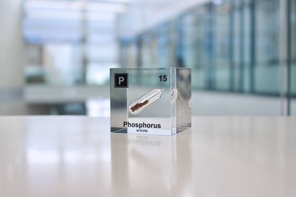 Clear acrylic cube displaying a Phosphorus element (Atomic Number 15) embedded within, offering a scientific presentation for collectors and science enthusiasts.