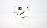 Clear acrylic cube displaying a Phosphorus element (Atomic Number 15) embedded within, offering a scientific presentation for collectors and science enthusiasts.