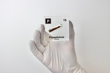 Clear acrylic cube displaying a Phosphorus element (Atomic Number 15) embedded within, offering a scientific presentation for collectors and science enthusiasts.