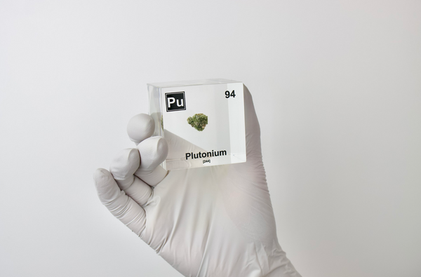 Clear acrylic cube displaying a Plutonium element (Atomic Number 94) embedded within, offering a scientific presentation for collectors and science enthusiasts.