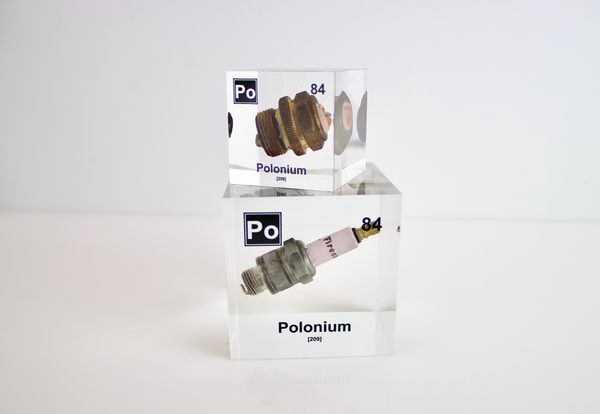 Clear acrylic cube showcasing a Polonium element (Atomic Number 84) embedded within, providing a scientific display for collectors and science enthusiasts.