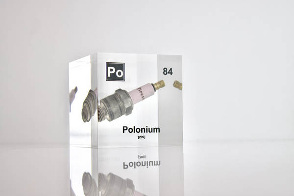 Clear acrylic cube showcasing a Polonium element (Atomic Number 84) embedded within, providing a scientific display for collectors and science enthusiasts.