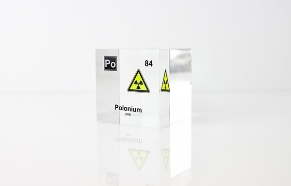 Clear acrylic cube displaying a Polonium element (Atomic Number 84) embedded within, offering a scientific presentation for collectors and science enthusiasts.