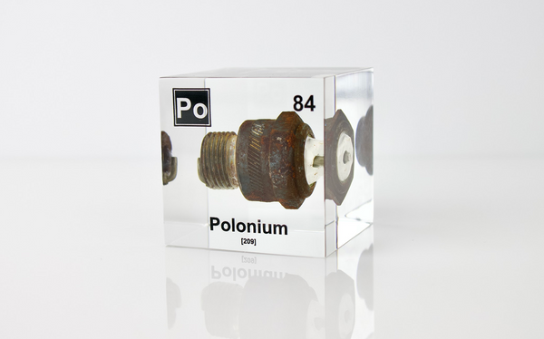 Clear acrylic cube displaying a Polonium element (Atomic Number 84) embedded within, offering a scientific presentation for collectors and science enthusiasts.