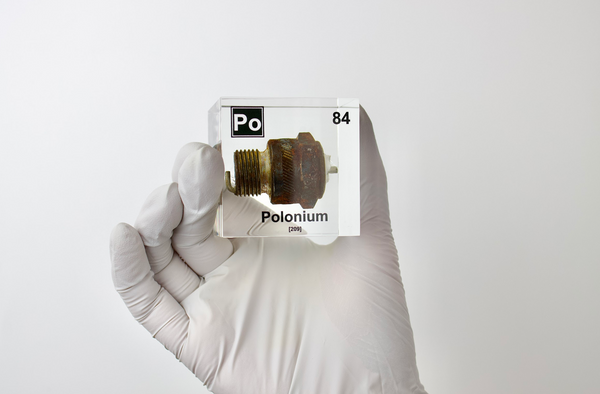 Clear acrylic cube displaying a Polonium element (Atomic Number 84) embedded within, offering a scientific presentation for collectors and science enthusiasts.