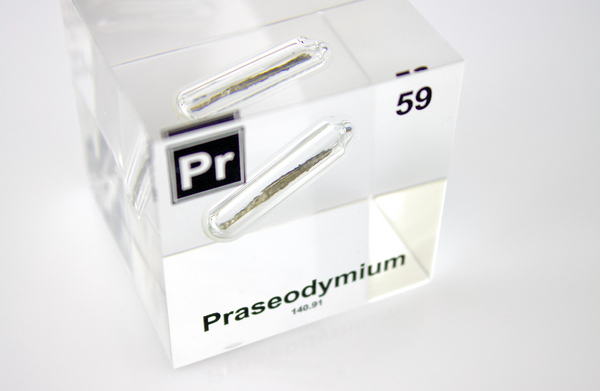 Clear acrylic cube displaying a Praseodymium element (Atomic Number 59) embedded within, offering a scientific presentation for collectors and science enthusiasts.