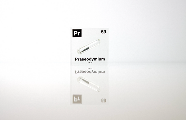 Clear acrylic cube displaying a Praseodymium element (Atomic Number 59) embedded within, offering a scientific presentation for collectors and science enthusiasts.