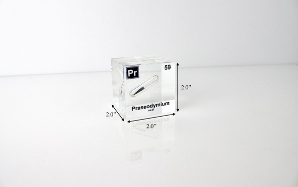 Clear acrylic cube displaying a Praseodymium element (Atomic Number 59) embedded within, offering a scientific presentation for collectors and science enthusiasts.