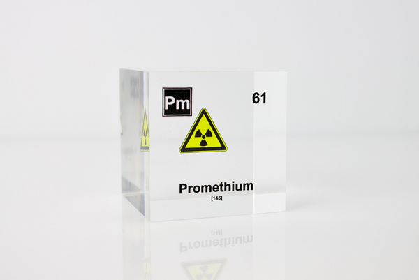 Clear acrylic cube displaying a Promethium element (Atomic Number 61) embedded within, offering a scientific presentation for collectors and science enthusiasts.