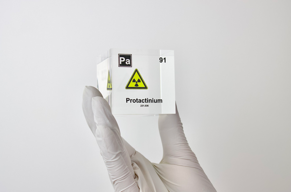 Clear acrylic cube displaying a Protactinium element (Atomic Number 91) embedded within, offering a scientific presentation for collectors and science enthusiasts.