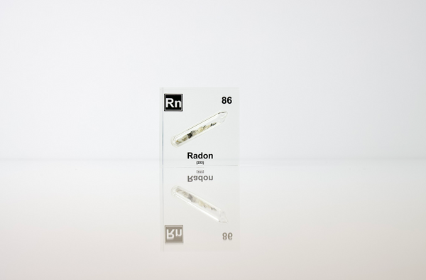 Clear acrylic cube displaying a Radon element (Atomic Number 86) embedded within, offering a scientific presentation for collectors and science enthusiasts.