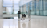Clear acrylic cube displaying a Rhodium element (Atomic Number 45) embedded within, offering a scientific presentation for collectors and science enthusiasts.