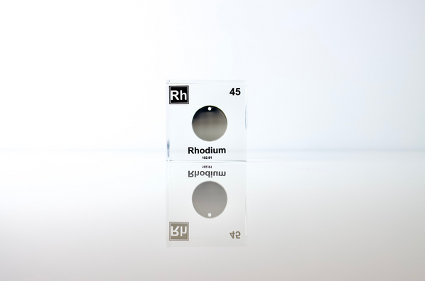 Clear acrylic cube displaying a Rhodium element (Atomic Number 45) embedded within, offering a scientific presentation for collectors and science enthusiasts.