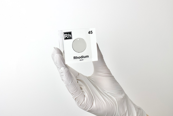 Clear acrylic cube displaying a Rhodium element (Atomic Number 45) embedded within, offering a scientific presentation for collectors and science enthusiasts.