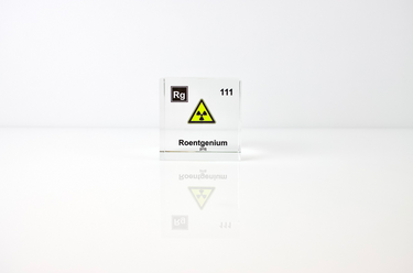 Clear acrylic cube displaying a Roentgenium element (Atomic Number 111) embedded within, offering a scientific presentation for collectors and science enthusiasts.