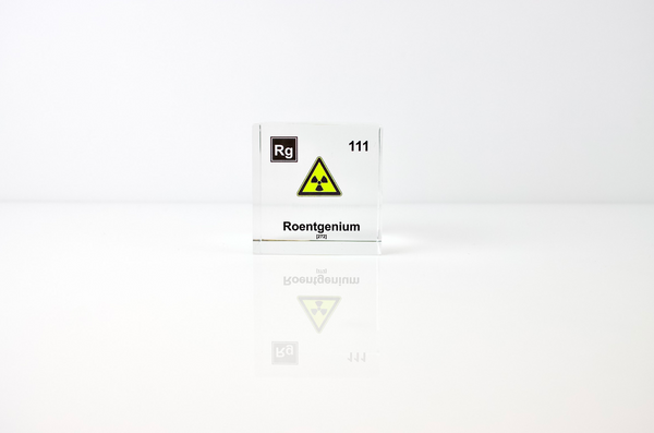 Clear acrylic cube displaying a Roentgenium element (Atomic Number 111) embedded within, offering a scientific presentation for collectors and science enthusiasts.