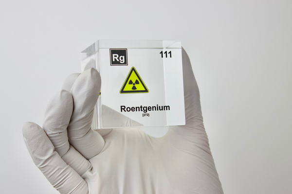 Clear acrylic cube displaying a Roentgenium element (Atomic Number 111) embedded within, offering a scientific presentation for collectors and science enthusiasts.