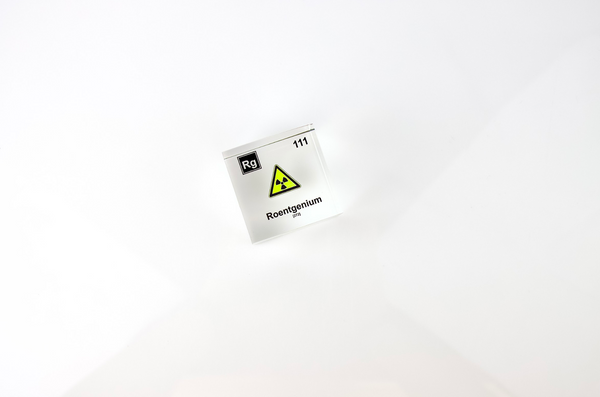 Clear acrylic cube displaying a Roentgenium element (Atomic Number 111) embedded within, offering a scientific presentation for collectors and science enthusiasts.