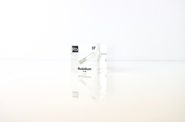 Clear acrylic cube displaying a Rubidium element (Atomic Number 37) embedded within, offering a scientific presentation for collectors and science enthusiasts.