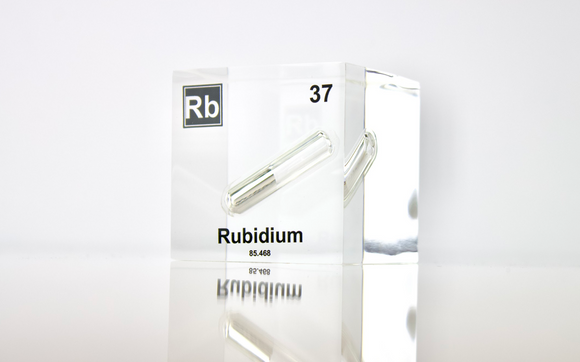 Clear acrylic cube displaying a Rubidium element (Atomic Number 37) embedded within, offering a scientific presentation for collectors and science enthusiasts.