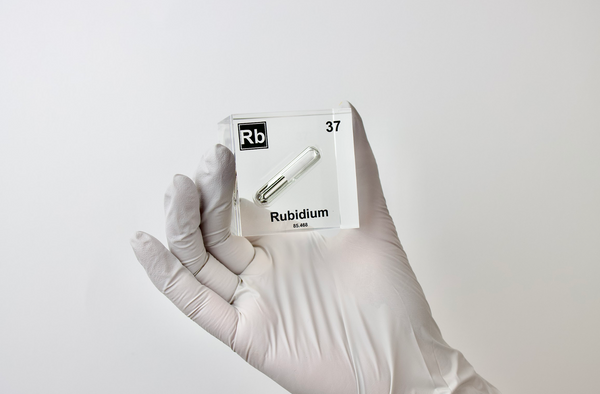 Clear acrylic cube displaying a Rubidium element (Atomic Number 37) embedded within, offering a scientific presentation for collectors and science enthusiasts.