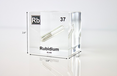 Clear acrylic cube displaying a Rubidium element (Atomic Number 37) embedded within, offering a scientific presentation for collectors and science enthusiasts.