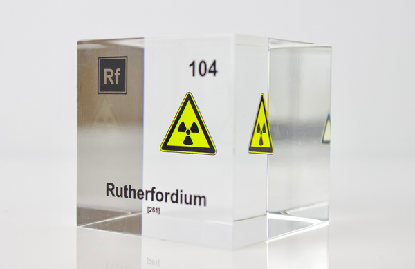 Clear acrylic cube displaying a Rutherfordium element (Atomic Number 104) embedded within, offering a scientific presentation for collectors and science enthusiasts.