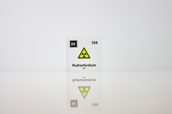 Clear acrylic cube displaying a Rutherfordium element (Atomic Number 104) embedded within, offering a scientific presentation for collectors and science enthusiasts.