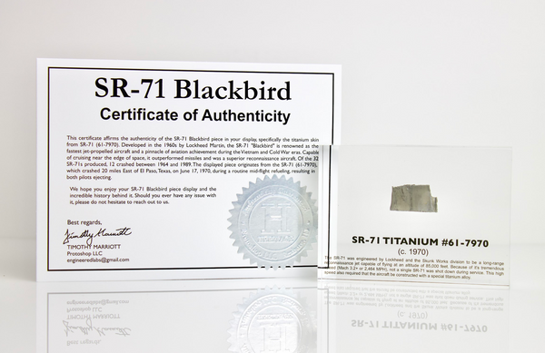 Close-up piece of SR-71 Blackbird titanium embedded in clear acrylic. The fragment is metallic and jagged, which highlights its history from the high-speed reconnaissance aircraft.