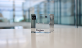Piece of Osmium encased in a clear acrylic cube, with the element's name, atomic number, and properties displayed as on the periodic table for a sleek, educational display.
