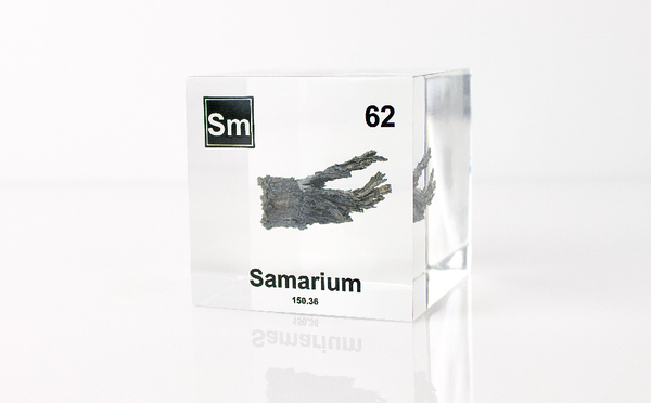 Clear acrylic cube displaying a Samarium element (Atomic Number 62) embedded within, offering a scientific presentation for collectors and science enthusiasts.